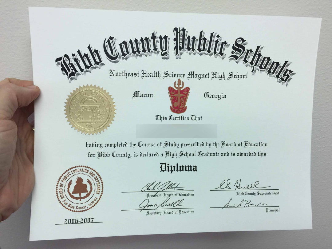 Hand holding a Quality High School diploma against a plain background