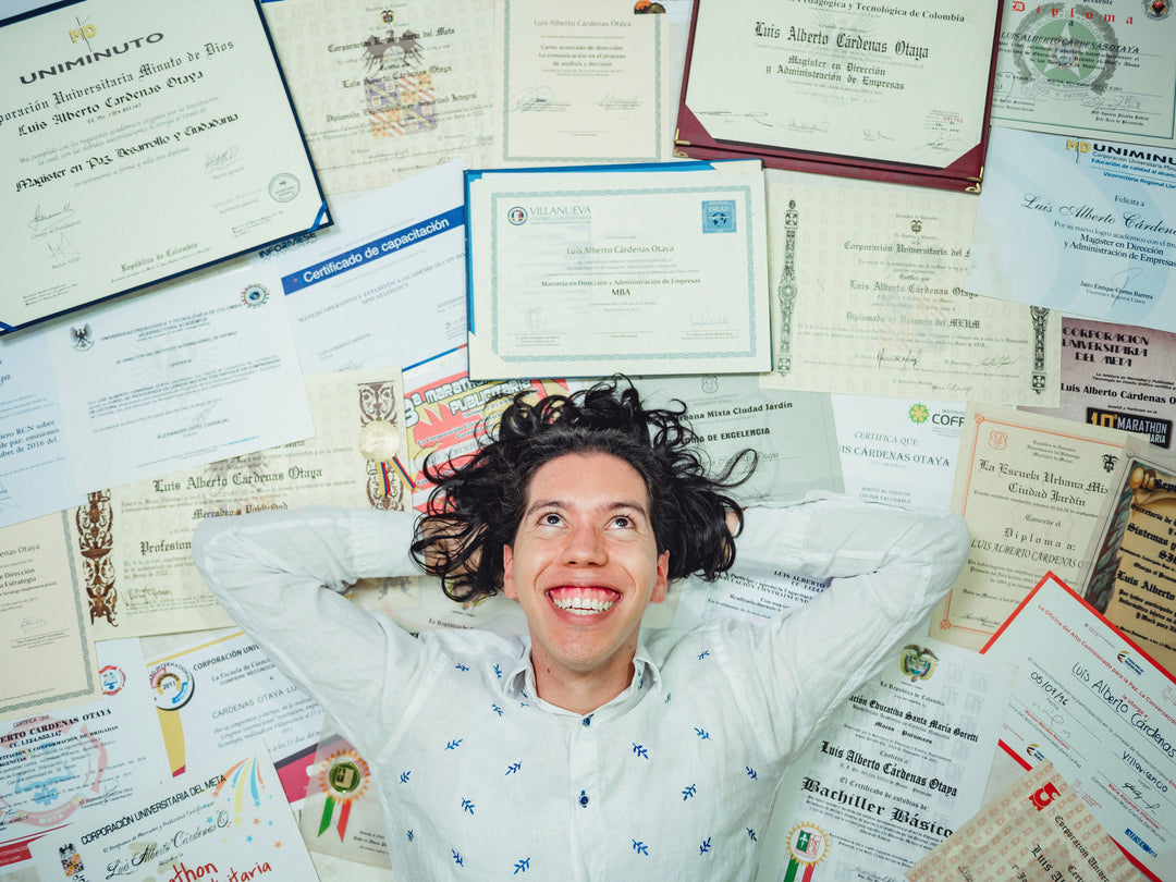 Person lying on a surface covered with various certificates and documents