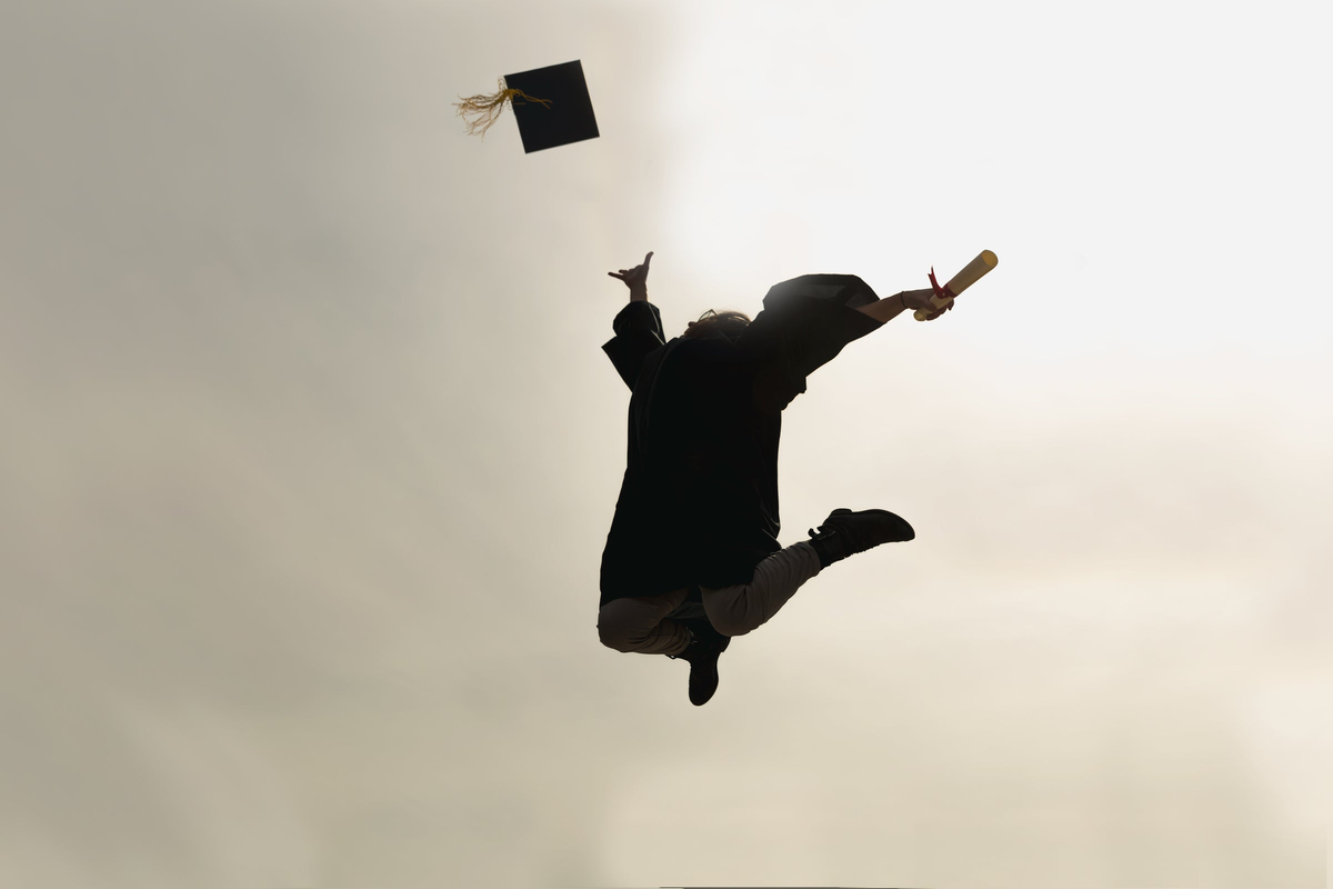 Person in silhouette with graduation cap and diploma against a light background